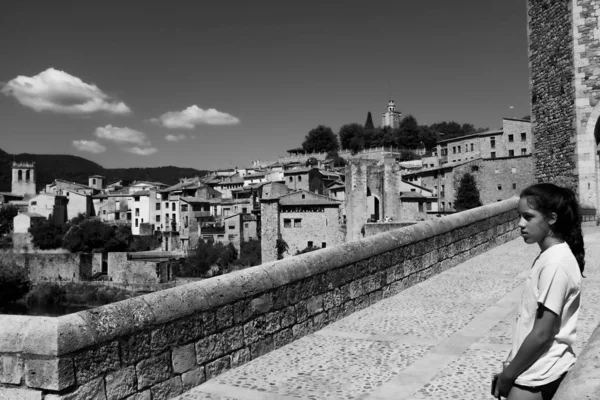 Besalu, Gerona tartomány, Spanyolország: fiatal lány turisztikai élvező középkori város. — Stock Fotó