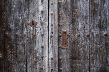Sahte perçinli eski gri ahşap kapı.