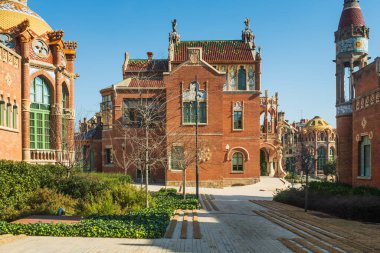 Barcelona 'daki eski Sant Pau Hastanesi Merkez Pavyonu' nun yan görüntüsü. Tüm kompleks tuğlalar, majolika, jöleli fayanslar, vitray ve mozaiklerle büyük süs zenginliğiyle karakterize edilir.. 