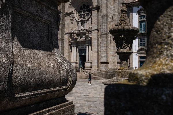 12世紀に建てられ 町の最も古い部分に位置するローマ ゴシック様式の建物 ポルト大聖堂の前を歩く保護面を持つ男 ポルトの中世の柱の横にあるサイドテラスから撮影 — ストック写真