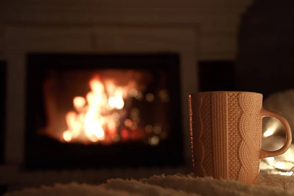 cup of tea. fire in the fireplace. concept of home comfort and warm atmosphere. cozy home