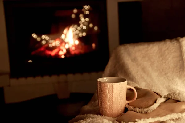 cup of tea. fire in the fireplace. concept of home comfort and warm atmosphere. cozy home