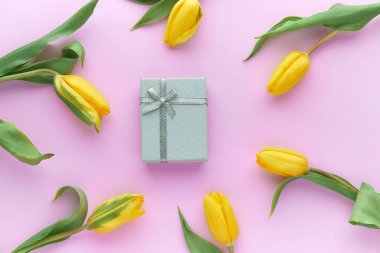 Sarı laleler ve hediye kutuları kopya alanı ile pembe bir arka plan üzerinde