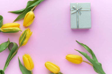 Sarı laleler ve hediye kutuları kopya alanı ile pembe bir arka plan üzerinde