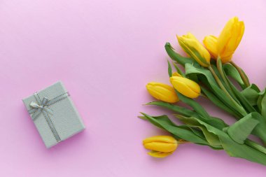 Sarı laleler ve hediye kutuları kopya alanı ile pembe bir arka plan üzerinde