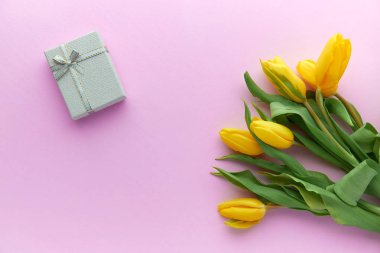 Sarı laleler ve hediye kutuları kopya alanı ile pembe bir arka plan üzerinde