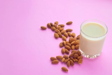 yulaf süt ve badem pastel pembe bir arka plan üzerinde şeffaf cam