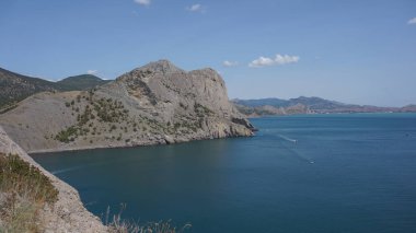 Deniz ve gökyüzü dağlar arasında 