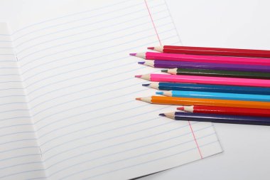 Okul ve öğrenciler için renkli kalemler. Kalem beyaz bir tablo üzerinde dağılmış ve bir cam stand. Ofis çalışanları için kalemler.