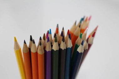 Okul ve öğrenciler için renkli kalemler. Kalem beyaz bir tablo üzerinde dağılmış ve bir cam stand. Ofis çalışanları için kalemler.