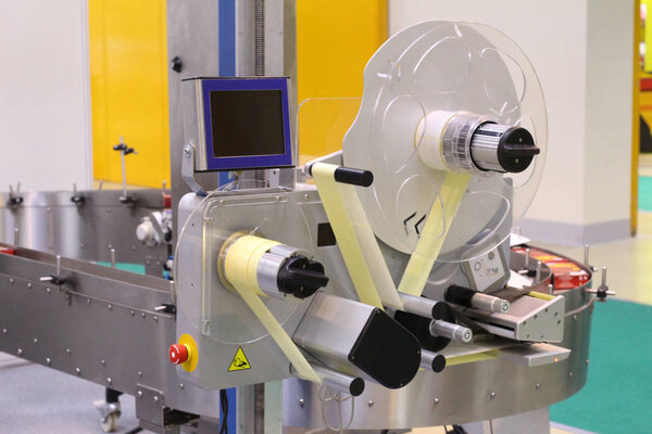 Machine for applying self-adhesive labels. The machine is designed for automatic labeling on a cylindrical container. The machine can apply a label made on a transparent tape.