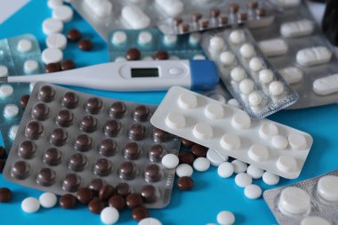 Bir saçılma masada tıbbi tablet. Yuvarlak hap ve kapsül. Eczane. Termometre sıcaklık ölçümü için.
