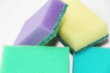 Beş çok renkli süngerler daire temizliği ve bulaşık için. Fotoğraf tüm sünger beyaz bir arka plan üzerinde renkli.