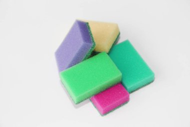Beş çok renkli süngerler daire temizliği ve bulaşık için. Fotoğraf tüm sünger beyaz bir arka plan üzerinde renkli.