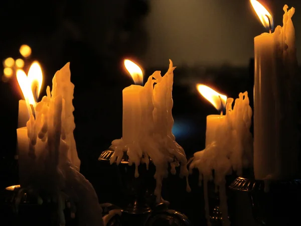 Muchas velas de parafina ardiendo en un candelero . — Foto de Stock