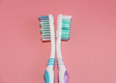 Pembe bir arka plan üzerinde iki diş fırçaları. Ağız hijyeni.