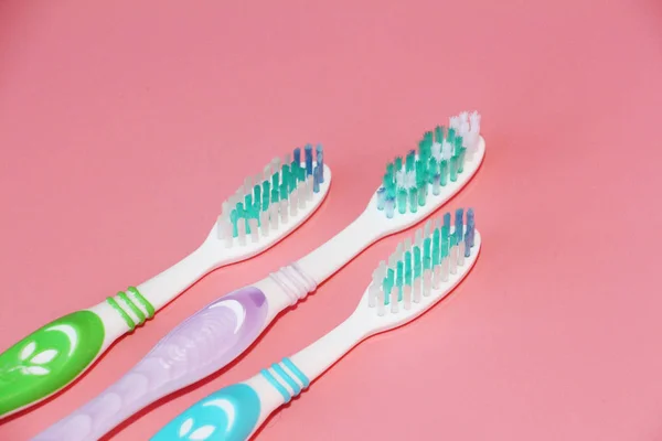 Trois brosses à dents sur fond rose. Hygiène orale . — Photo