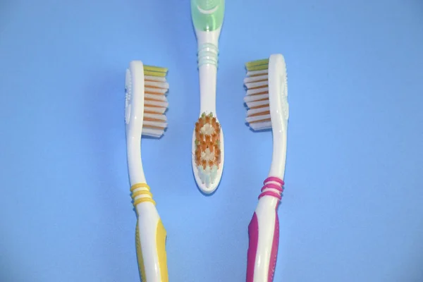 Three toothbrushes on a blue background. Oral hygiene. — Stock Photo, Image