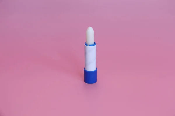 Lápiz labial higiénico sobre fondo rosa. Cosméticos para niños, hombres y mujeres . — Foto de Stock