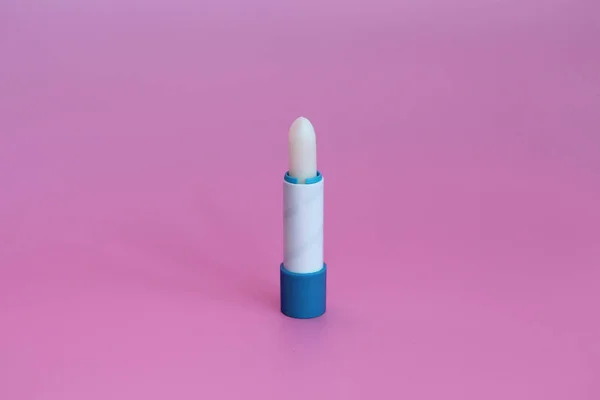 Lápiz labial higiénico sobre fondo rosa. Cosméticos para niños, hombres y mujeres . — Foto de Stock