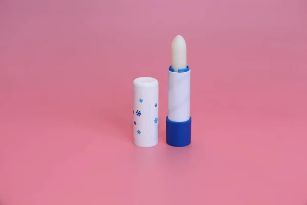 Lápiz labial higiénico sobre fondo rosa. Cosméticos para niños, hombres y mujeres . — Foto de Stock