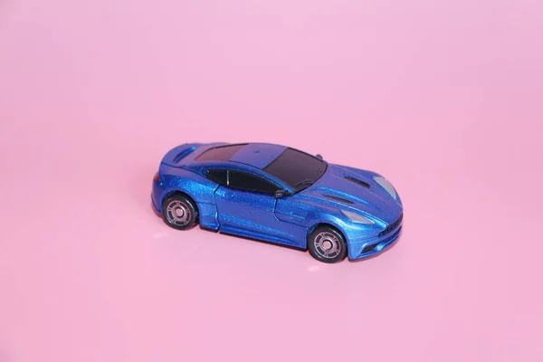 ピンクの背景の青いスポーツおもちゃの車。子供のためのおもちゃ。T — ストック写真