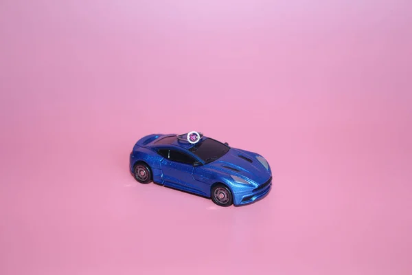 The blue sports car bears a ring with a crystal heart.