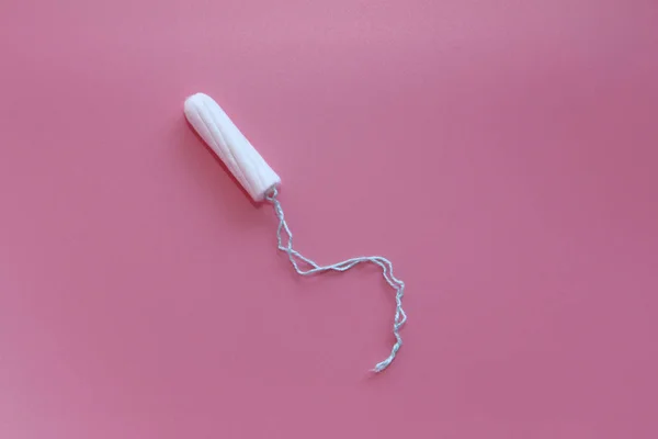 Tampón médico femenino sobre fondo rosa. Tampón blanco higiénico para mujeres . — Foto de Stock