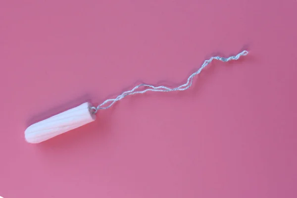 Tampón médico femenino sobre fondo rosa. Tampón blanco higiénico para mujeres . — Foto de Stock