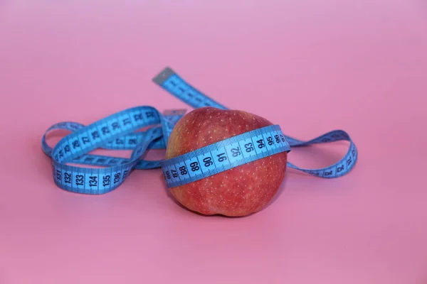 Blue tape for measuring the body around an apple. — Stock Photo, Image