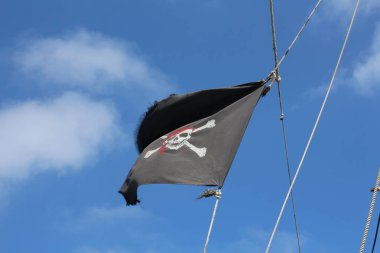 Korsan bayrağı gökyüzünde geliştirmektedir. Bayrak bir kafatası ile siyah.