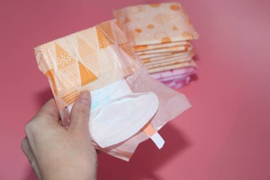 Gül bir arka plan üzerinde bireysel ambalaj çeşitli sıhhi yastıkları vardır.