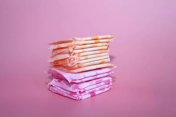 Sobre un fondo de rosa hay varias toallas sanitarias . — Foto de Stock