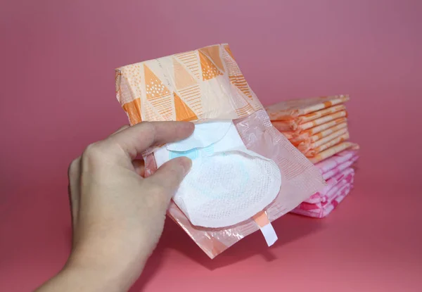 Gül bir arka plan üzerinde bireysel ambalaj çeşitli sıhhi yastıkları vardır.