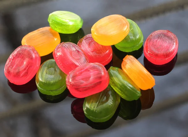 Яркие конфеты карамель разбросаны на темном фоне . — стоковое фото