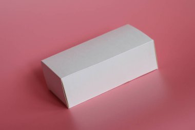 Pembe bir arka plan üzerinde beyaz kutu yatıyor. Yatay beyaz kutu.