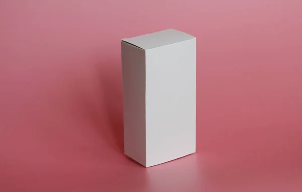 La caja blanca está sobre un fondo rosa. Caja blanca vertical . — Foto de Stock