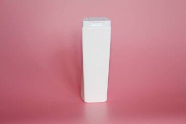 Pembe bir arka plan üzerinde bir plastik şişe. Şişe kozmetikler için.