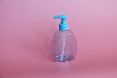 Bir mavi şişe pembe bir arka plan üzerinde. Şişe dispenseri ile kozmetikler için.