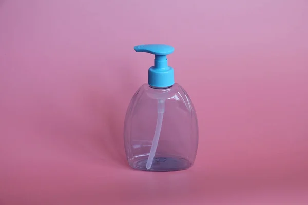 Ένα μπλε μπουκάλι σε ροζ φόντο. Μπουκάλι για καλλυντικά με αεροζόλ. — Φωτογραφία Αρχείου