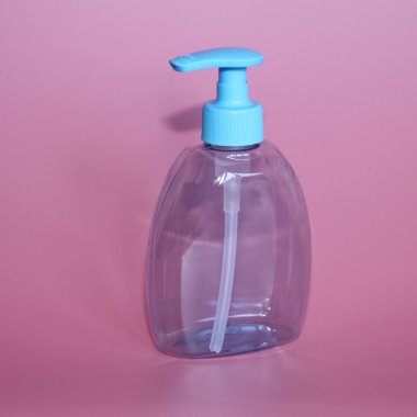 Bir mavi şişe pembe bir arka plan üzerinde. Şişe dispenseri ile kozmetikler için.