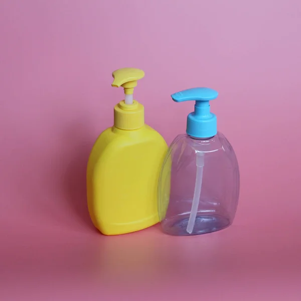 Дві пластикові пляшки на рожевому тлі. Пляшки для косметики з дозатором . — стокове фото
