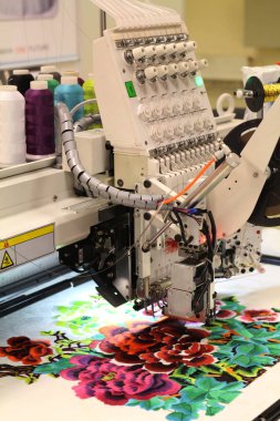 Tekstil üretimi. Makine bir çiçek desenli embroiders.