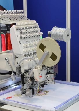 Tekstil üretimi. Makine bir çiçek desenli embroiders.