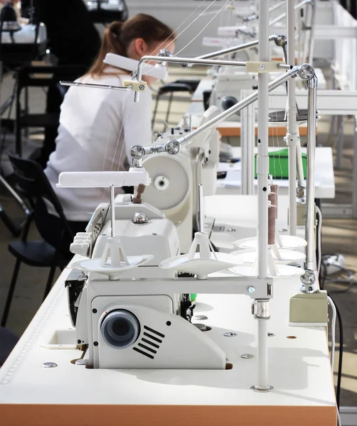 Factory about sewing clothes. People and sewing machines at a garment factory.