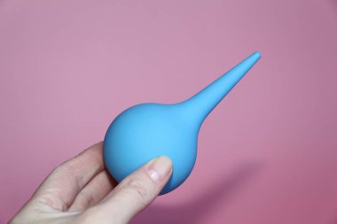 Mavi bir el yumuşak bir ipucunda şırınga.