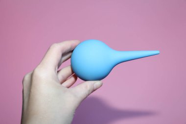 Mavi bir el yumuşak bir ipucunda şırınga.