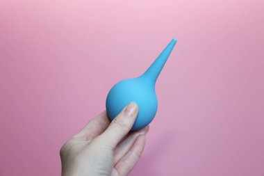 Mavi bir el yumuşak bir ipucunda şırınga.