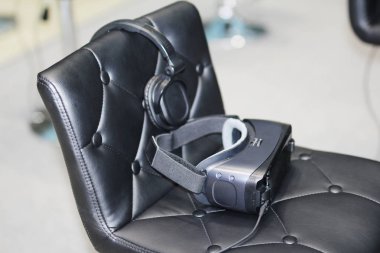 Sandalyede kulaklıklar ile sanal gerçeklik için gözlük vardır.