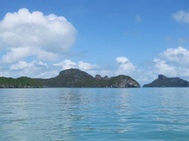 Ufukta bulutların ve turkuaz denizin birleştiği mavi gökyüzü.